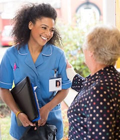 EMPOWERING FAMILIES WITH COMPREHENSIVE IN-HOME CARE 14 SENIOR WOMAN GREETING CAREGIVER AT FRONT DOOR